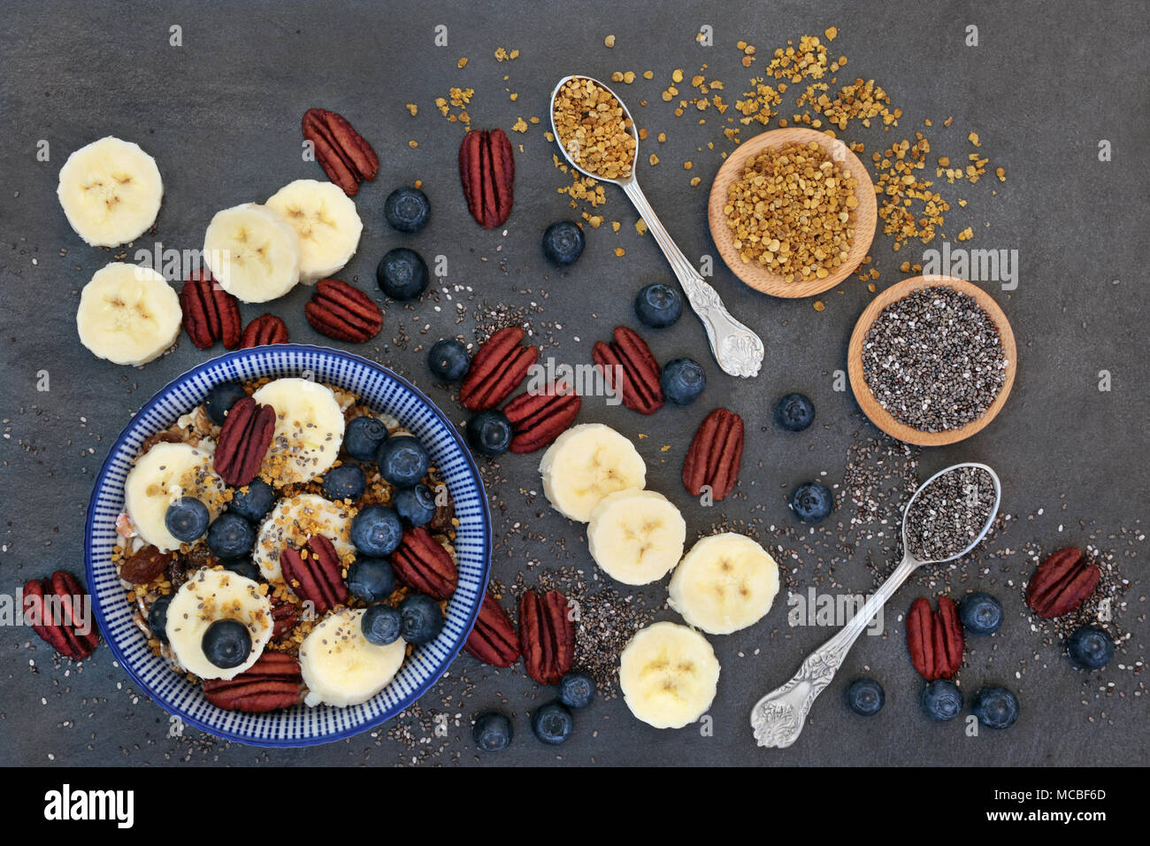 Pour le petit-déjeuner santé macrobiotique concept avec la banane, céréales, grains de pollen, des petits fruits, noix et graines de chia avec des aliments riches en protéines, o Banque D'Images