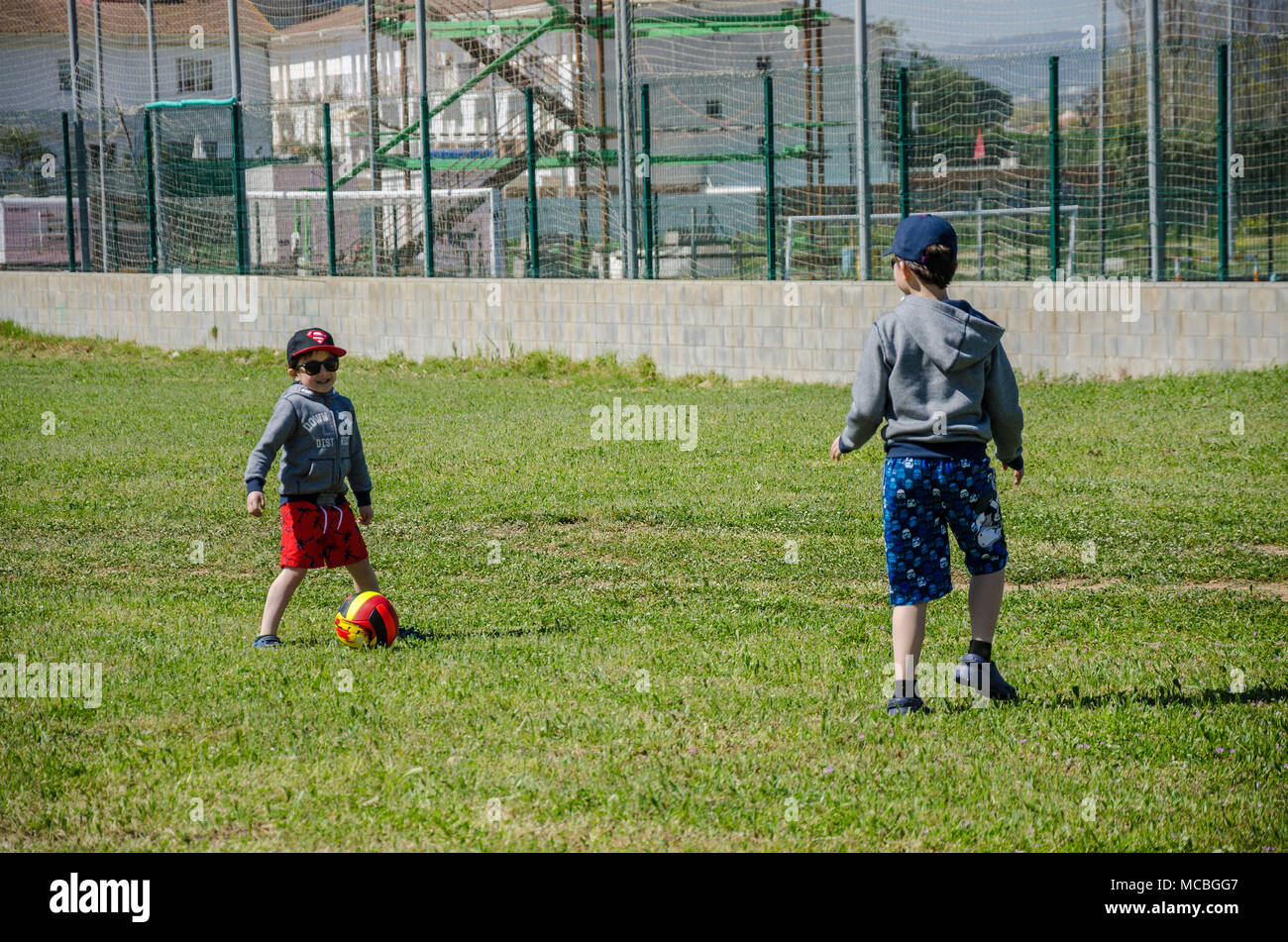 De jeunes garçons jouent au football ensemble sur une zone d'herbe pendant les vacances en Snata, Espagne. Banque D'Images