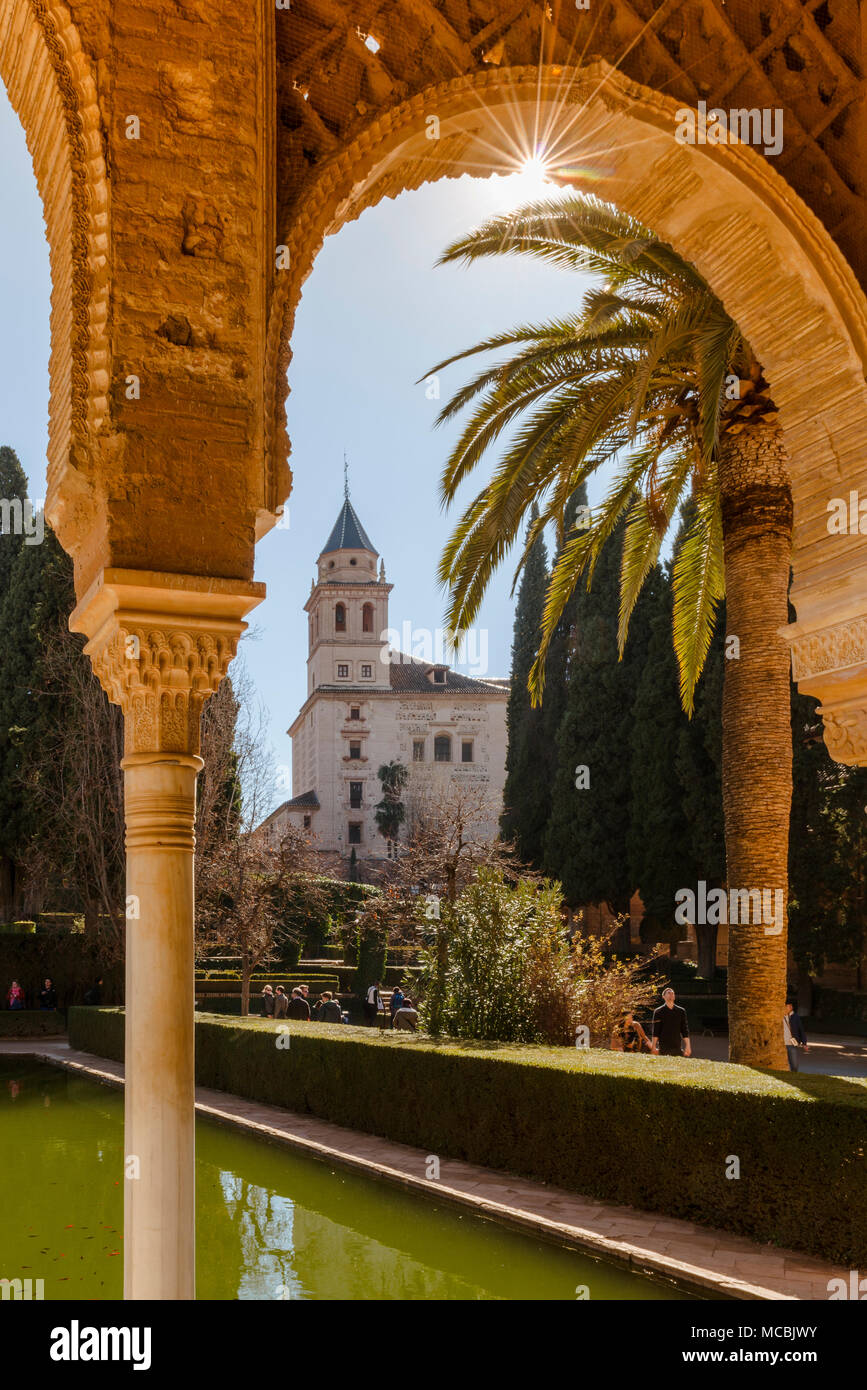 Vue à travers une arcade, église de Santa María de la Alhambra, El Partal avec piscine et palmiers, à l'Alhambra Banque D'Images