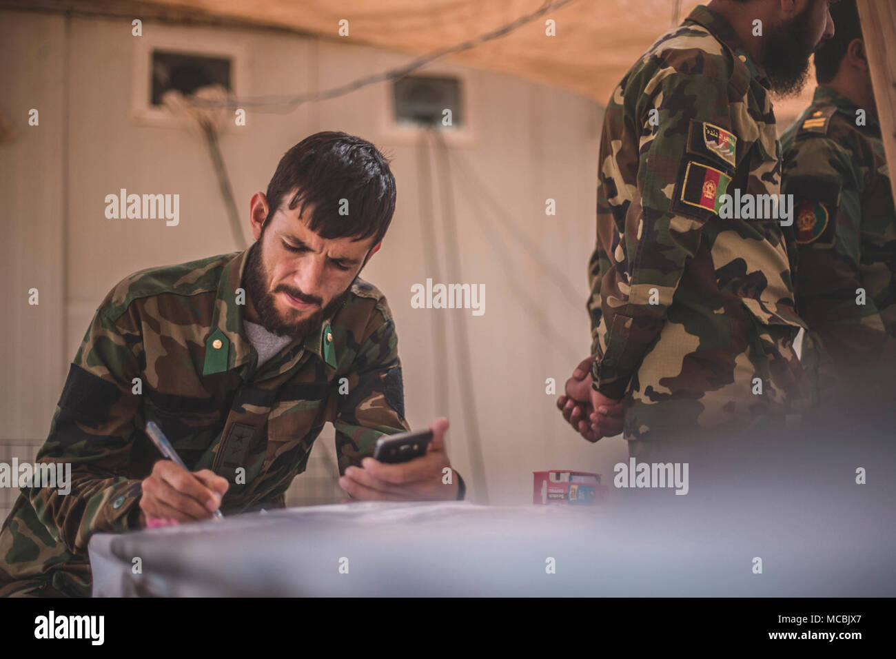 Un soldat avec 1ère Brigade, l'Armée nationale afghane (ANA) 215e amies et ennemies des parcelles de Corps endroits pendant le fonctionnement Maiwand 12 Shorserack au Camp, l'Afghanistan, le 12 mars 2018. Maiwand 12 est une opération dirigée par les Afghans, TFSW-assistée, avec éléments de manoeuvre du 215e Corps de l'ANA, Direction nationale de la sécurité, et 505ème de la Police nationale afghane de Zone d'expansion des forces de la zone de sécurité dans la province de Helmand. Banque D'Images