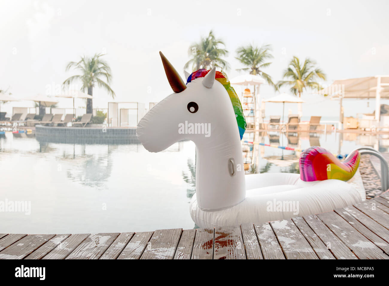 Jouet gonflable coloré piscine unicorn près du bord de piscine sur tropical resort Banque D'Images