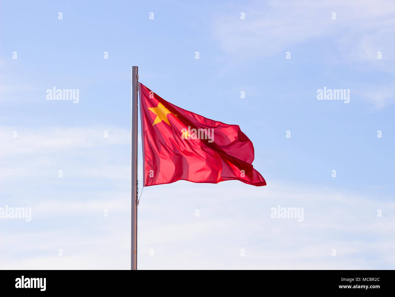 Drapeau chinois en fond de ciel bleu vif, drapeau rouge avec étoile jaune battant en été , vent soufflant du pavillon des ressortissants chinois. Banque D'Images