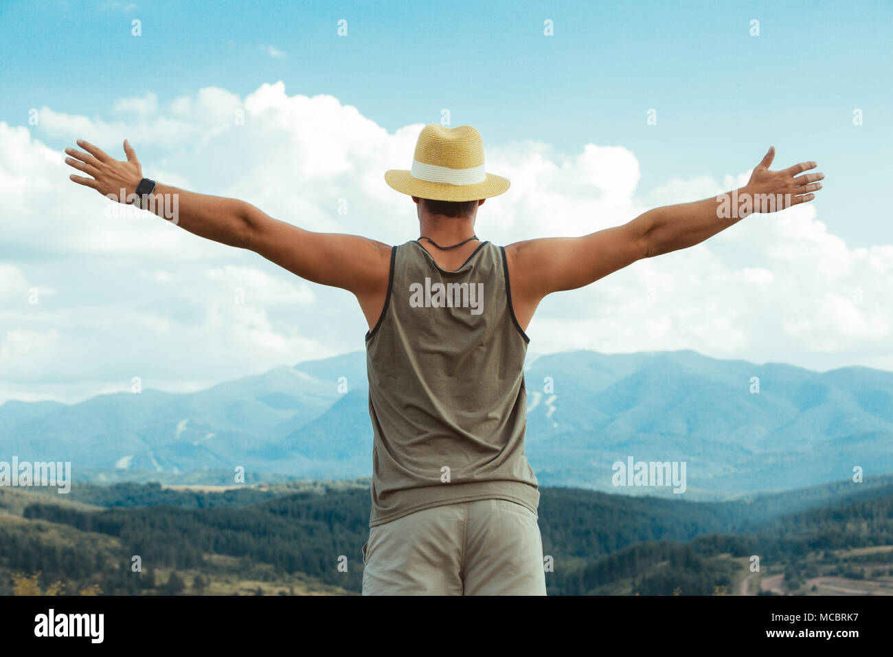 Jeune homme de la randonnée dans les montagnes de Rila, Bulgarie. l'homme tient dans ses mains les côtés. Vue arrière Banque D'Images