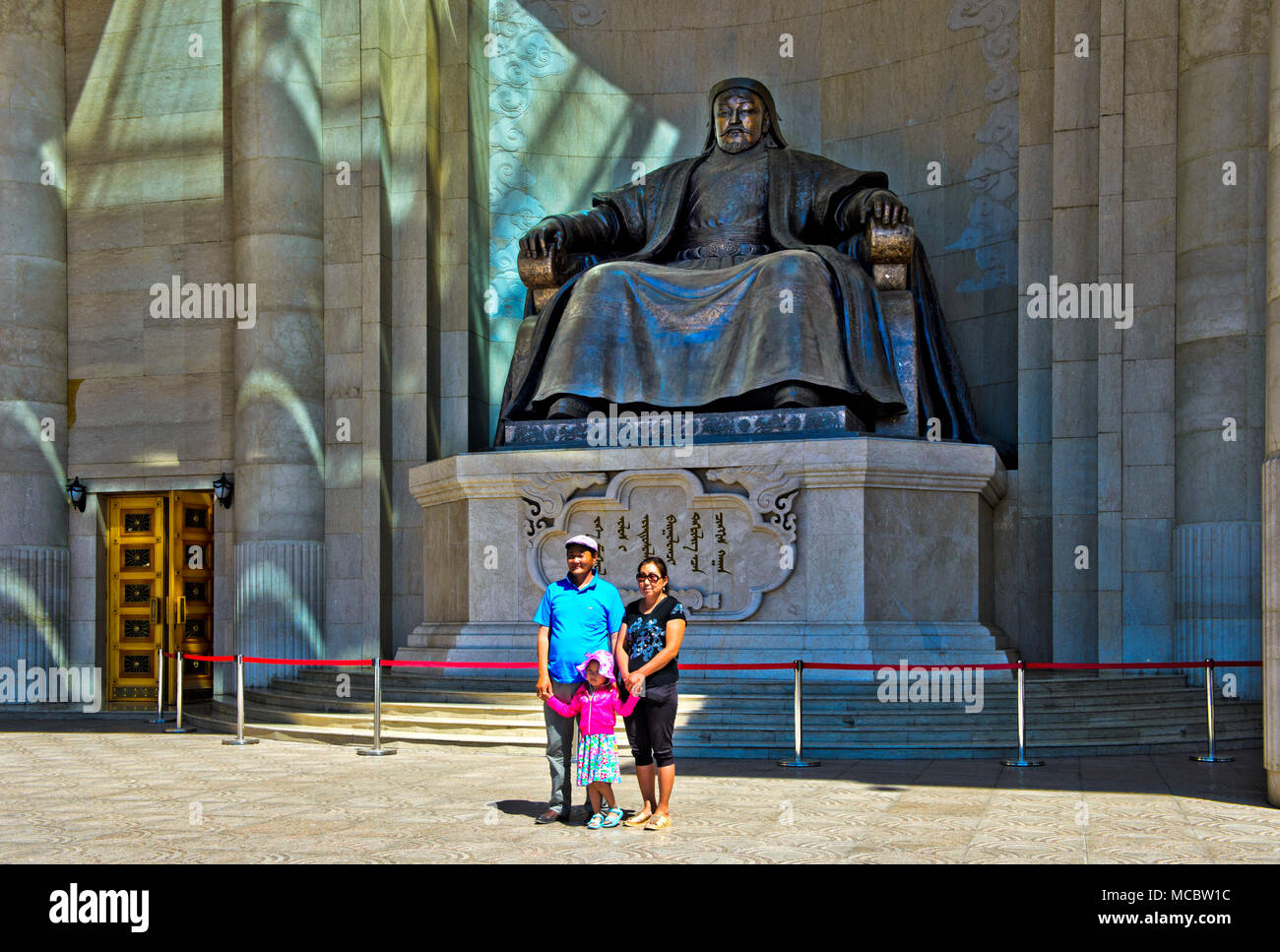 Mongolian couple avec enfant debout pour une photo souvenir devant le monument de Gengis Khan à l'édifice du Parlement sur Sukhbaatar Square, Oulan Banque D'Images