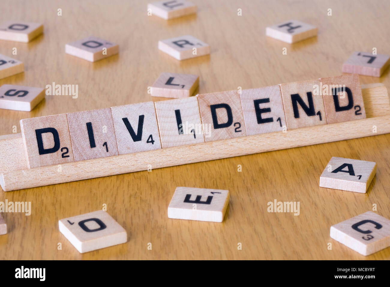 Des lettres Scrabble qui orthographient le mot dividende. Concept - le marché boursier, les dividendes d'entreprise, le marché financier, l'investissement, les actions et les actions Banque D'Images