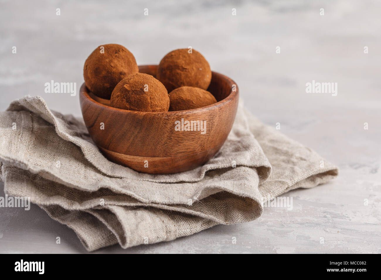 L'énergie brute végétalien sain fait maison avec des boules de truffe en caroube bol en bois. Banque D'Images