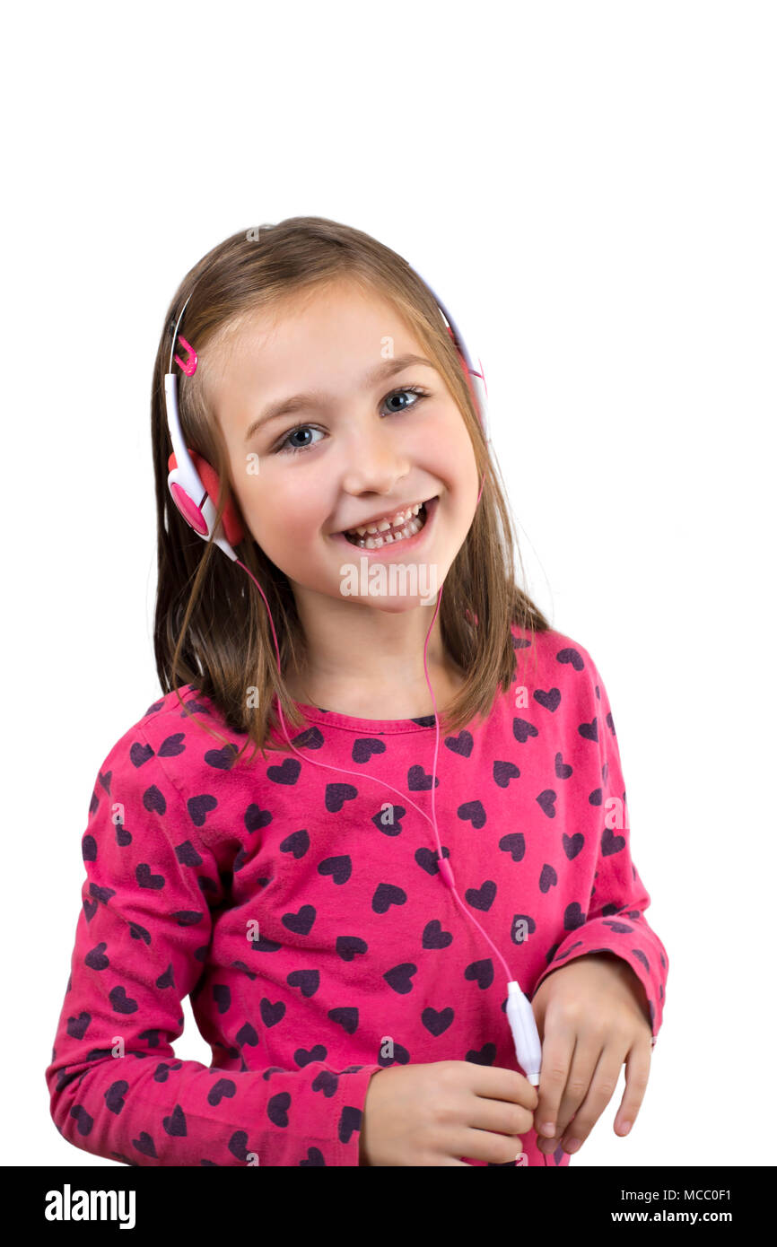 Petite fille heureuse avec un casque s'amusant à écouter la musique, isolé sur blanc. Banque D'Images