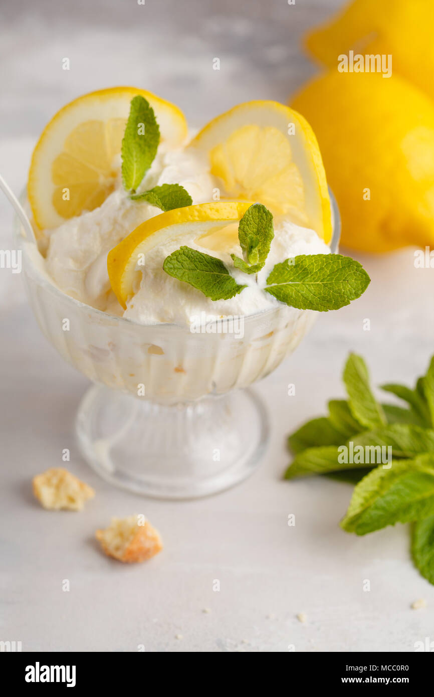 Dessert Citron, citron trifle, gâteau au fromage, crème fouettée, parfait. Mousse de fruits en verre sur un fond clair. Banque D'Images