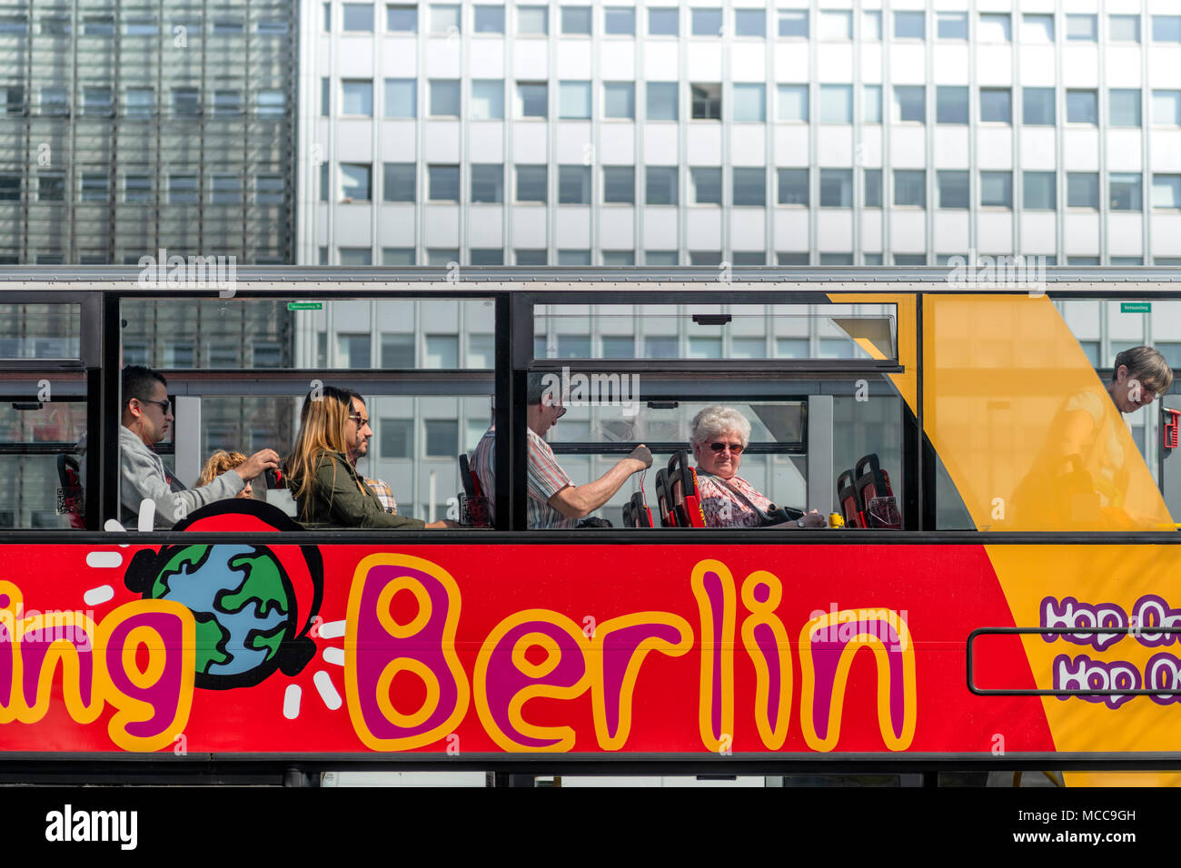 Les gens s'assoient sur le pont supérieur d'un des nombreux 'Hop On, Hop Off' des bus qui sont une attraction touristique dans la capitale allemande de Berlin. Banque D'Images