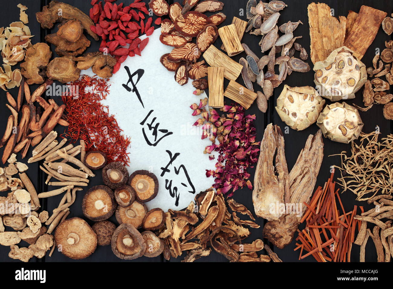 Les herbes chinoises traditionnelles utilisées en médecine alternative avec script calligraphie sur le riz pape sur fond de bois sombre. La traduction se lit comme herbe chinoise Banque D'Images