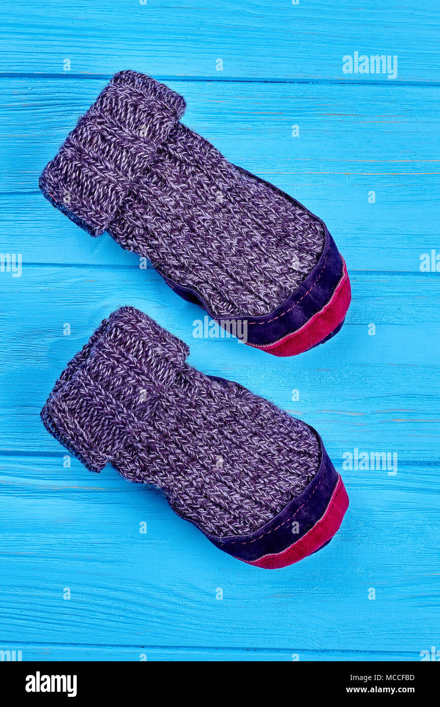 Laine naturelle prix chaussons. Chaussettes de laine tricotées avec semelles en cuir rouge et violet close up. Tricoter des chaussettes d'hiver pour les enfants. Banque D'Images