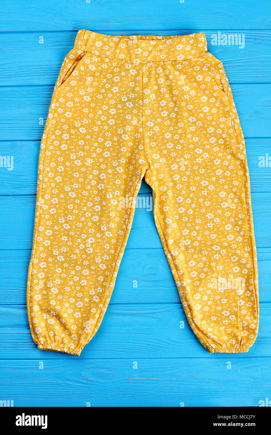 Pantalon Bébé fille d'été, vue du dessus. Pantalon Bébé fille été jaune sur  bleu fond de bois Photo Stock - Alamy