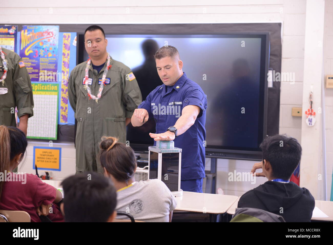 Maître de 2e classe Matthieu Garcia, Coast Guard District 14 Gestion des voies navigables, de discussions avec les étudiants sur les aides à la navigation au cours de la journée d'orientation de l'école intermédiaire Waipahu, le 9 février 2018. L'équipage avec des emplois différents tout au long de l'arrondissement sont venus parler aux élèves au sujet de la vaste gamme de possibilités la Garde côtière présente. (U.S. Photo de la Garde côtière canadienne par le maître de 3e classe Amanda Levasseur/libérés) Banque D'Images