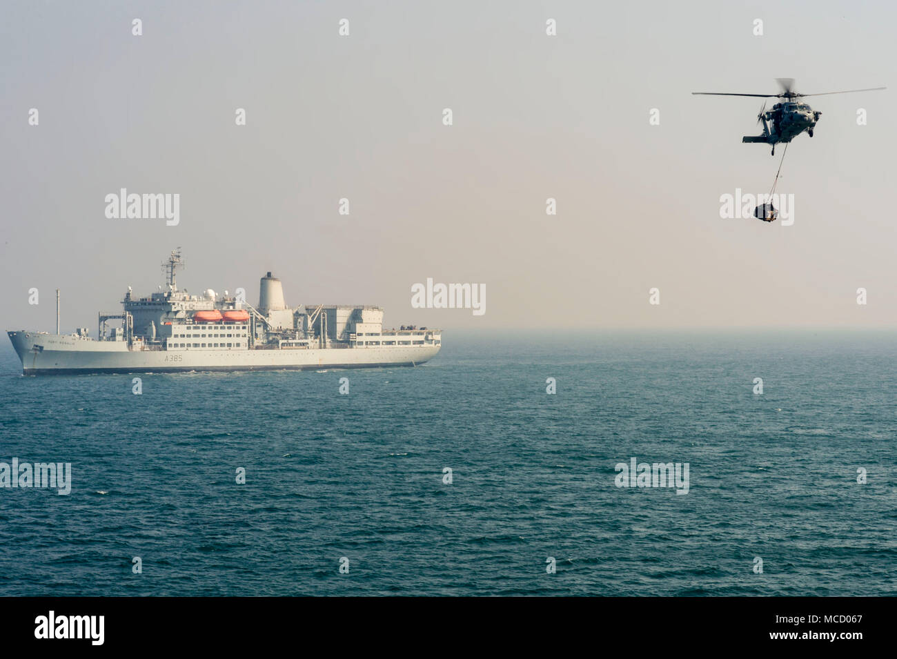 180208-N-VT388-1044 GOLFE Arabo-persique (fév. 8, 2018) Un MH-60S Sea Hawk offre de fret vers la cruiser lance-missiles USS Bunker Hill (CG 52) lors d'un ravitaillement vertical avec le Royaume-Uni's Royal Fleet Auxiliary (RFA) Fort Rosalie (A385). Bunker Hill est déployé avec le groupe aéronaval du Theodore Roosevelt à la 5e flotte américaine zone d'opérations à l'appui d'opérations de sécurité maritime pour rassurer les alliés et les partenaires et de préserver la liberté de navigation et la libre circulation du commerce dans la région. (U.S. Photo par marine Spécialiste de la communication de masse 1ère classe R. David Val Banque D'Images