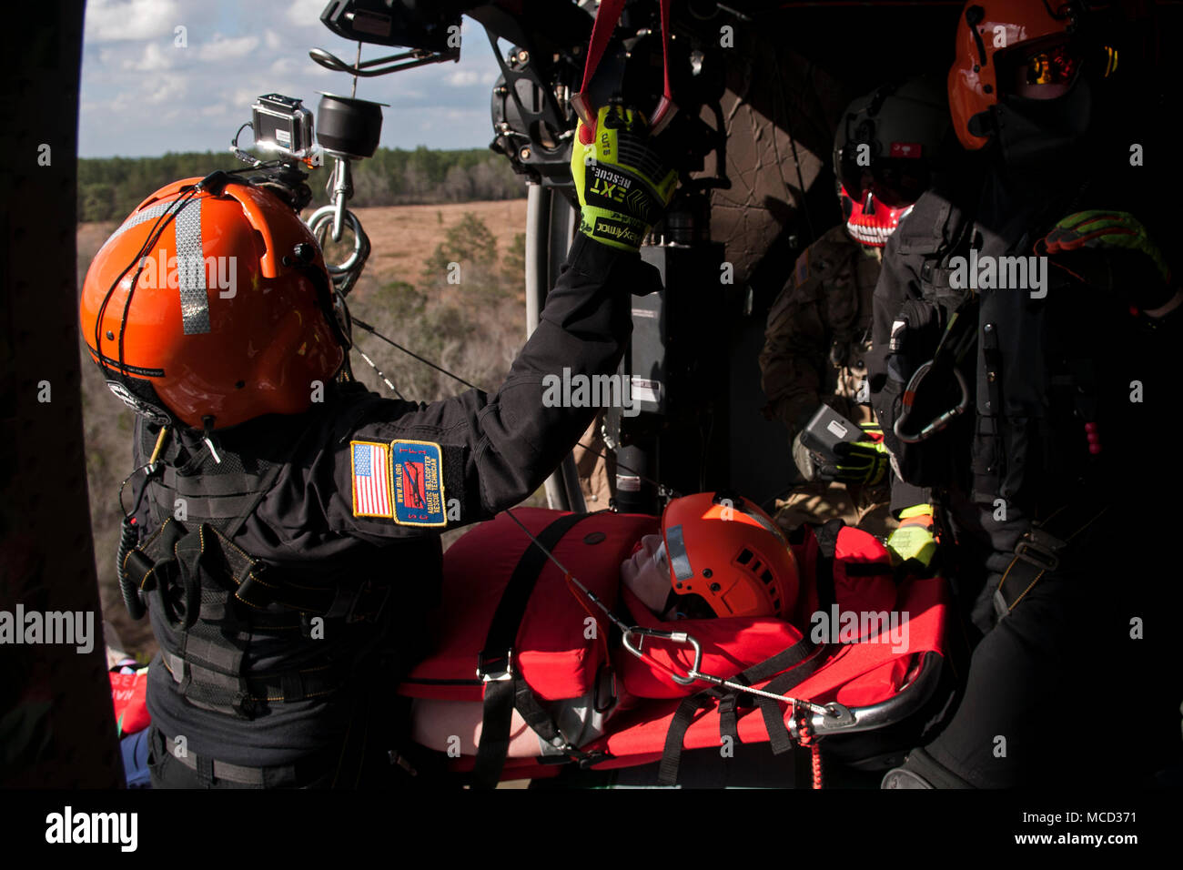 Les membres de l'hélicoptère de la Caroline du Sud et de l'équipe de sauvetage aquatique avec les soldats de la Garde nationale de Caroline du Sud simuler un sauvetage par hélicoptère sur un UH-60 Black Hawk au cours de l'exercice 18 du patriote au camp Shelby, Mississippi, le 15 février 2018. Du Sud 2018 PATRIOT teste les capacités combinées de la Garde nationale, ainsi que des organismes d'État et locaux, de répondre lors de catastrophes naturelles à l'aide de simulation de scénarios d'urgence. (U.S. Photo de la Garde nationale aérienne par le sergent. Wendy Kuhn) Banque D'Images