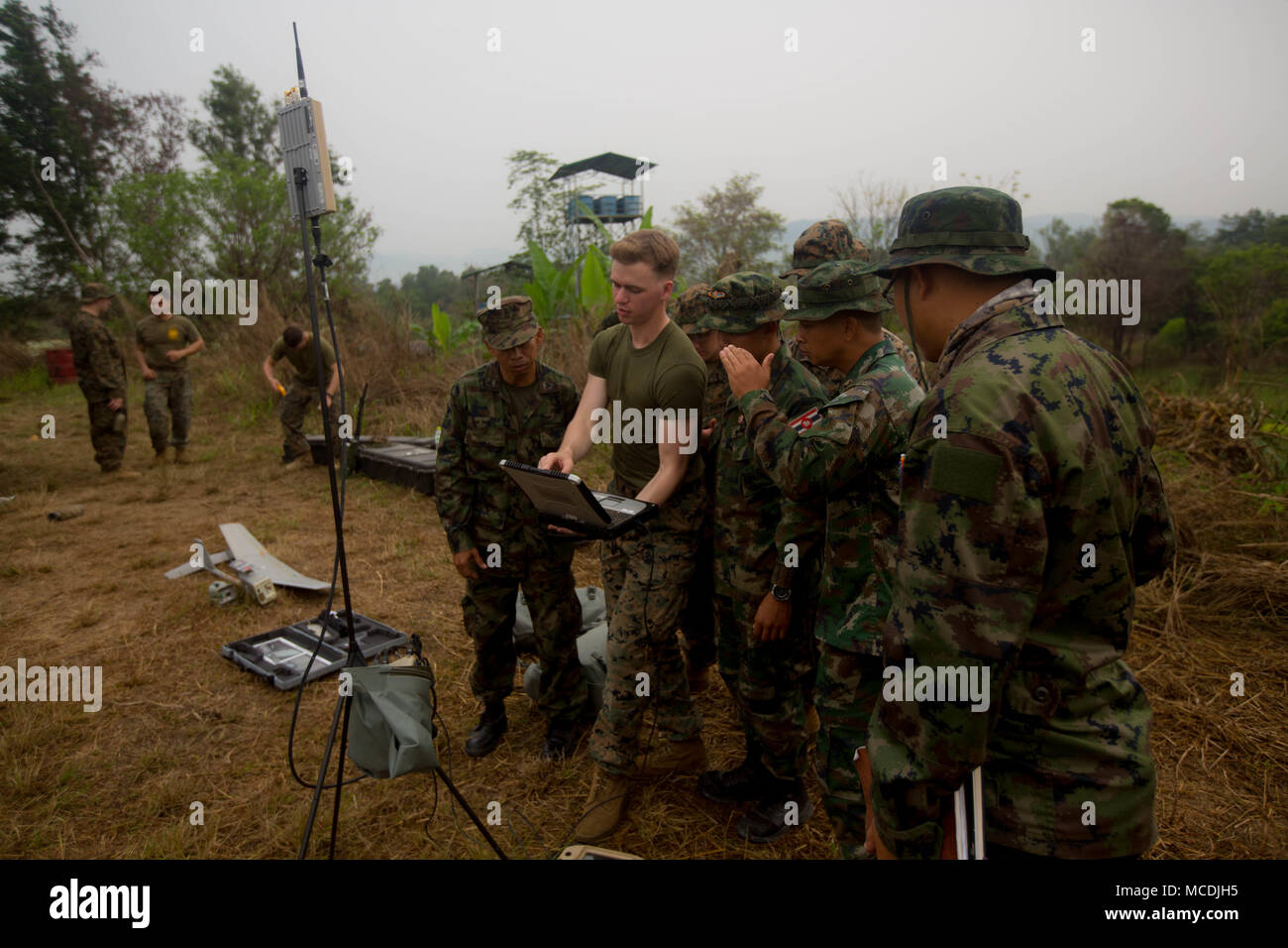 Le Caporal des Marines des États-Unis. Kyle Bougeno avec 3e Bataillon, 3e Régiment de Marines, explique l'utilisation d'un ordinateur portable et ses diverses capacités d'alimentation vidéo à ses homologues thaïlandais au camp de Ban Chan Khrem, le Royaume de Thaïlande, le 19 février, 2018.Bougeno, un Pevely, Missouri, natif sert d'analyste du renseignement et d'un petit exploitant de systèmes aériens sans pilote. Gold Cobra 18 est un exercice annuel effectué dans le royaume de Thaïlande et se déroule du 10 févr. 13 à 23 avec 12 nations participantes. (U.S. Marine Corps photo par le Sgt. Robert Arellano) Banque D'Images