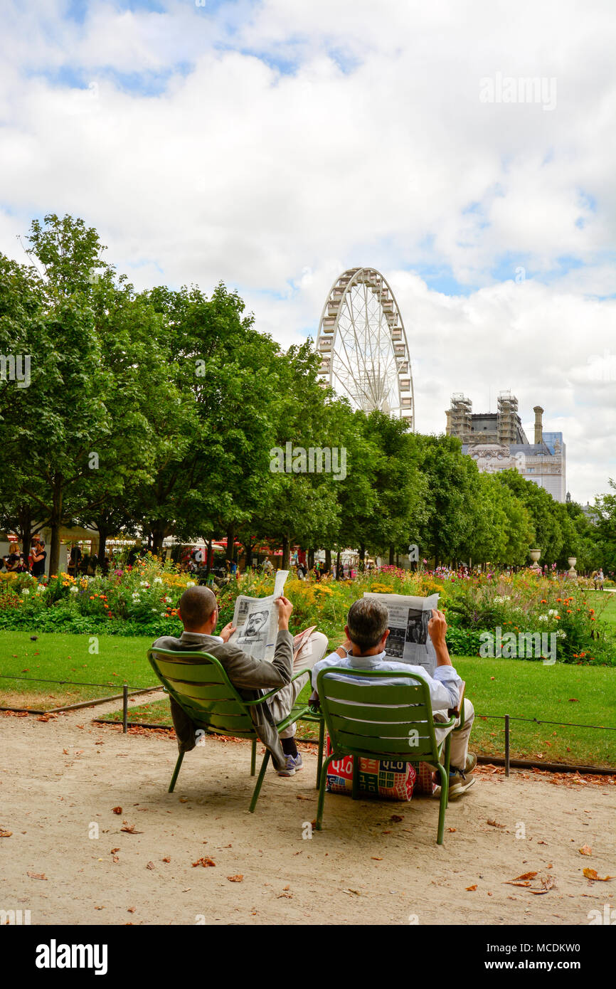 Un couple lisant le journal à l'Tuellieries jardins du Louvre à Paris. Banque D'Images