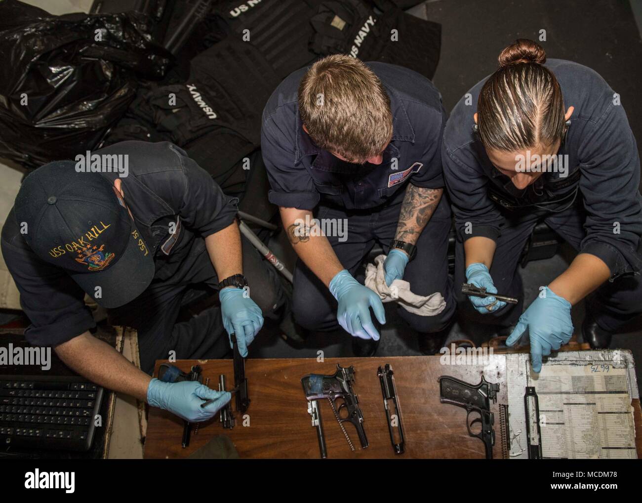 180220-N-TJ319-0207 OCÉAN ATLANTIQUE (fév. 20, 2018) Gunner's Mate 3 Classe Kyle Breese (à gauche), Gunner's Mate Seaman Alexander Harrison et Gunner's Mate 2e classe Alyssia Faifili effectuer la maintenance sur 9 mm pistolets à bord du navire de débarquement dock USS Oak Hill (LSD 51). L'Iwo Jima Groupe amphibie se lance la 26e Marine Expeditionary Unit et Oak Hill comprend, le navire d'assaut amphibie USS Iwo Jima (DG 7), le transport amphibie Navire dock USS New York (LPD 21), l'équipe chirurgicale de la flotte d'hélicoptères de combat, 8 Mer 28 Escadron, l'Escadron de contrôle aérien tactique, 22 composantes de la plage Marine Grou Banque D'Images