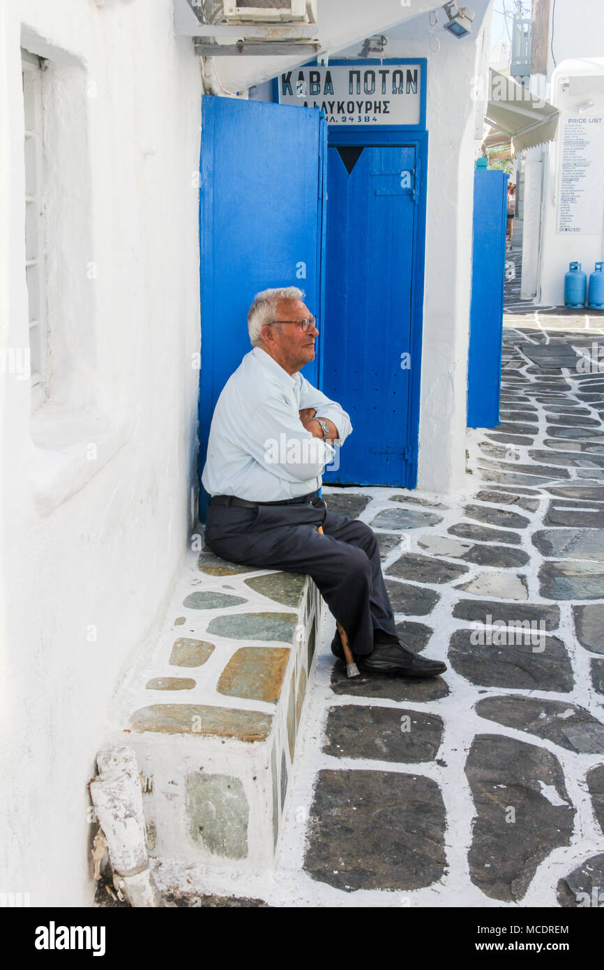 Homme s'assit sur le siège de Pierre, Chora, Mykonos, Grèce Banque D'Images