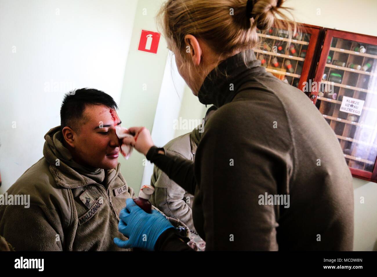 Le Sgt polonais. Frencho Zohra, un infirmier de la 11e Division de cavalerie blindée (droite), s'applique aux blessures faux U.S. Army PFC. Adrian Maldonado, un spécialiste des systèmes de prise en charge de signaux, avec le 82e bataillon du génie de la Brigade Blindée, 2e Brigade Combat Team, 1re Division d'infanterie, au cours d'un exercice de gestion de crise dans la région de Zagan, Pologne le 26 février 2018. La formation multinationale a été fait pour augmenter l'interopérabilité avec les premiers intervenants polonais et de forces armées alors qu'à l'appui de la résolution de l'Atlantique. (U.S. Photo de l'armée par la CPS. Hubert D. Delany III / 22e Détachement des affaires publiques mobiles) Banque D'Images