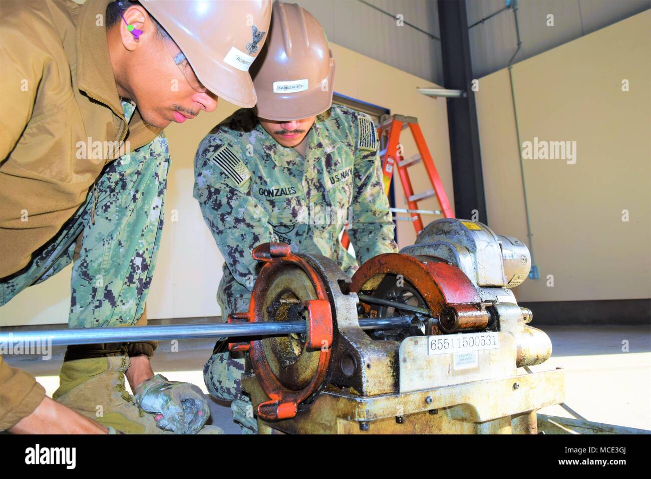 180216-N-NO818-0001 Yokosuka, Japon (fév. 16, 2018) Électricien de construction 2e classe Utilitiesman Constructionman Gerald Roberts et Marc Gonzales, tous deux affectés à la construction navale (bataillon Mobile NMCB) 4, utiliser un machines à couper les filets dans le conduit à utiliser pour le câblage électrique à l'intérieur du bâtiment préfabriqués (PEB). 4 NMCB est déployée en avant vers le Pacifique, prête à soutenir des opérations de combat majeures, l'aide humanitaire/opérations de secours en cas de catastrophe, et fournir un soutien à l'ingénierie générale, de la marine, du Corps des Marines et des forces opérationnelles. (U.S. Photo par Steelwo marine Banque D'Images