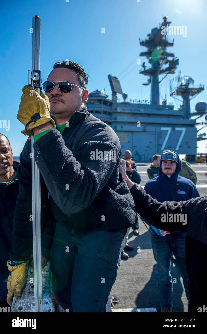 180227-N-NG136-323 OCÉAN ATLANTIQUE (fév. 27, 2018) Communications de l'intérieur 3e classe Électricien Andres Munoz vérifie l'alignement de l'amélioration de l'optique d'une lentille de Fresnel (IFLOLS Système d'atterrissage) pour le Conseil d'inspection et d'enquête (INSURV) à bord du porte-avions USS George H. W. Bush (CVN 77). Le navire est actuellement en cours pour l'INSURV hébergement matériel du navire d'inspection. (U.S. Photo par marine Spécialiste de la communication de masse de la classe 3ème Zachary P. Wickline/libérés) Banque D'Images