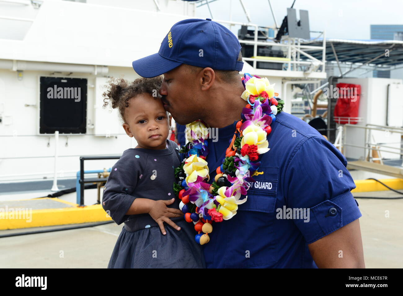 Le lieutenant J.G. Joshua Martin, de la direction, de la Garde côtière canadienne Joseph Gerczak (CMP 1126) tient sa fille après l'arrivée de la faucheuse à son nouveau port d'attache d'Honolulu le 4 février 2018, à la suite d'un transit de 42 jours à partir de Key West, Floride. Le Gerczak est le deuxième des trois 154 pieds de coupeurs de réponse rapide d'arriver à New York. (U.S. Photo de la Garde côtière canadienne par le Premier maître de Sara Muir/libérés) Banque D'Images