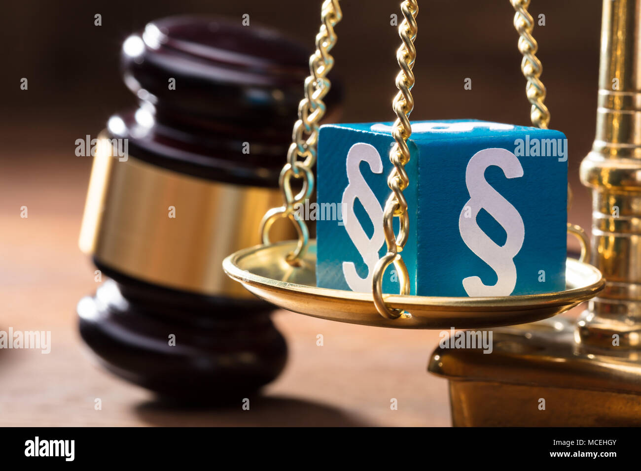 Close-up of Blue Paragraphe Bloc sur l'échelle d'or avec maillet sur le bureau en bois Banque D'Images