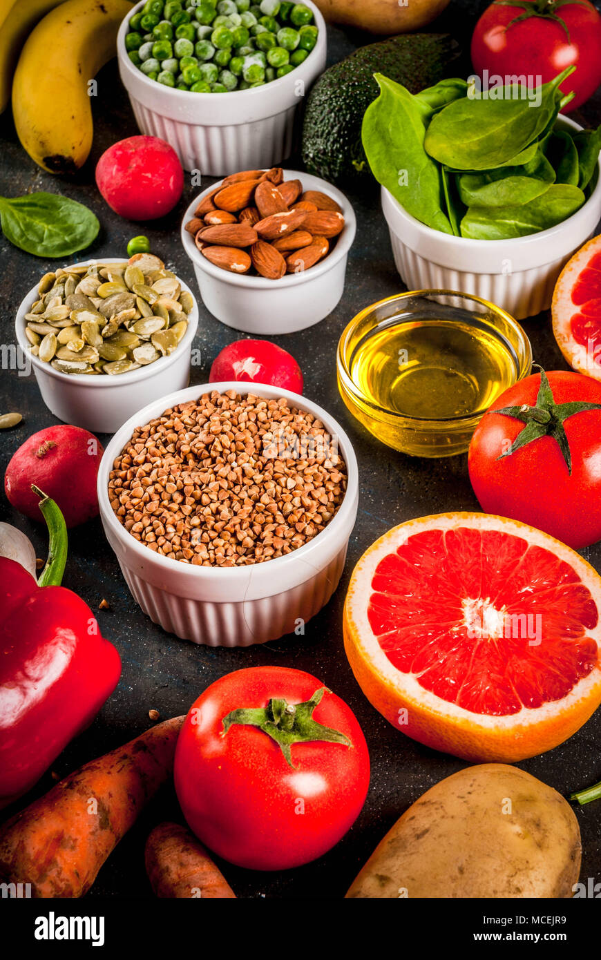 Arrière-plan de la nourriture saine, des produits de régime alcalin - fruits, légumes, céréales, noix, huiles. bleu foncé fond béton Banque D'Images
