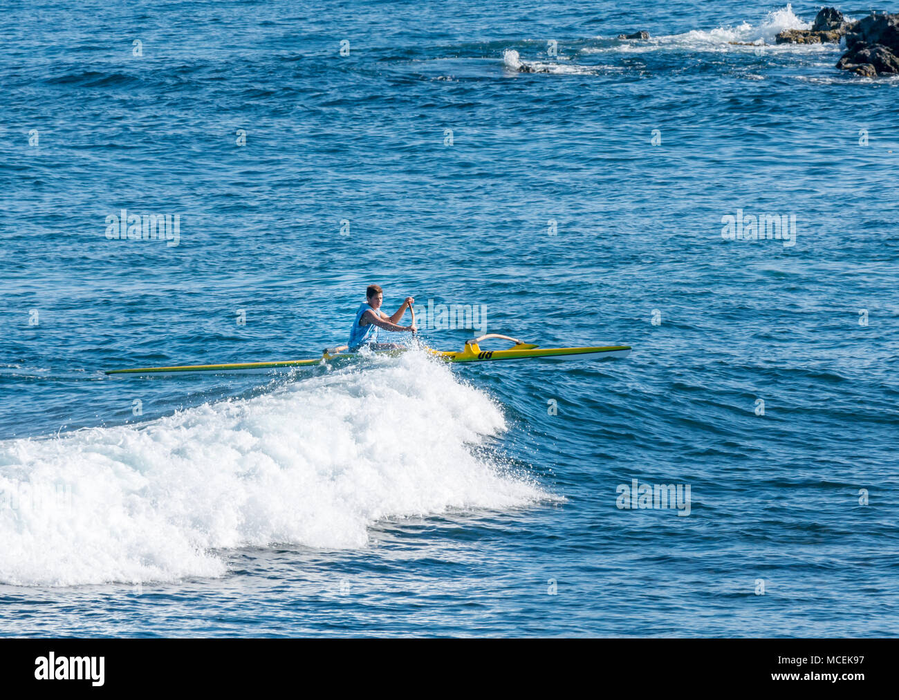 L'homme Local pirogue à pagaie sur la crête des vagues, l'île de Pâques, Chili, Amérique du Sud Banque D'Images