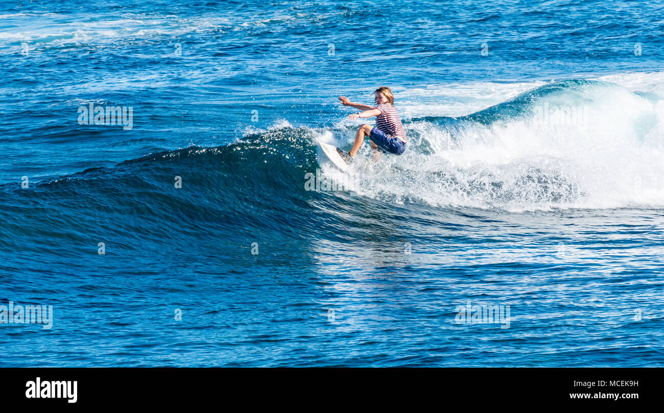 Caucasian man with long hair surf wave crest sur planche de surf, l'île de Pâques, Chili, Amérique du Sud Banque D'Images