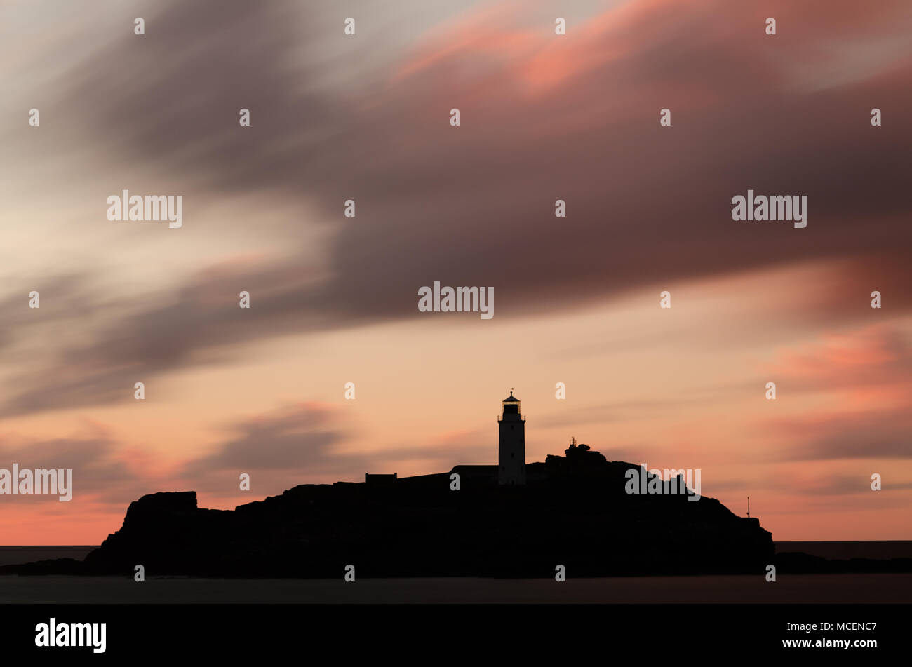 Déménagement nuages sur Godrevy Lighthouse au coucher du soleil Banque D'Images