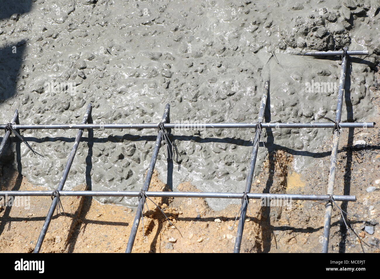 Mouiller le béton est coulé dans un treillis métallique en acier, Banque D'Images