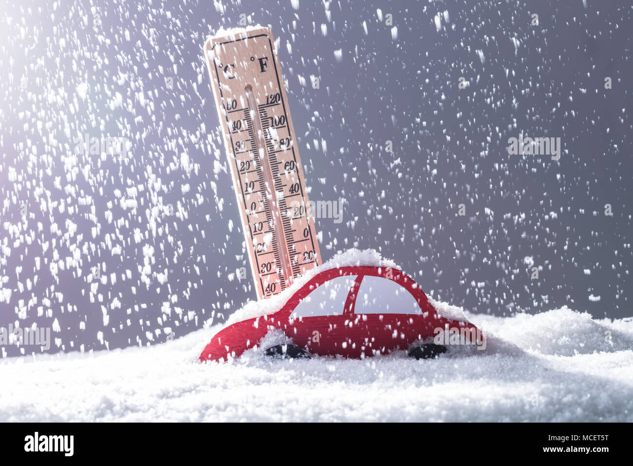 Voiture rouge couverte de neige en face de thermomètre au cours de fortes chutes de neige Banque D'Images