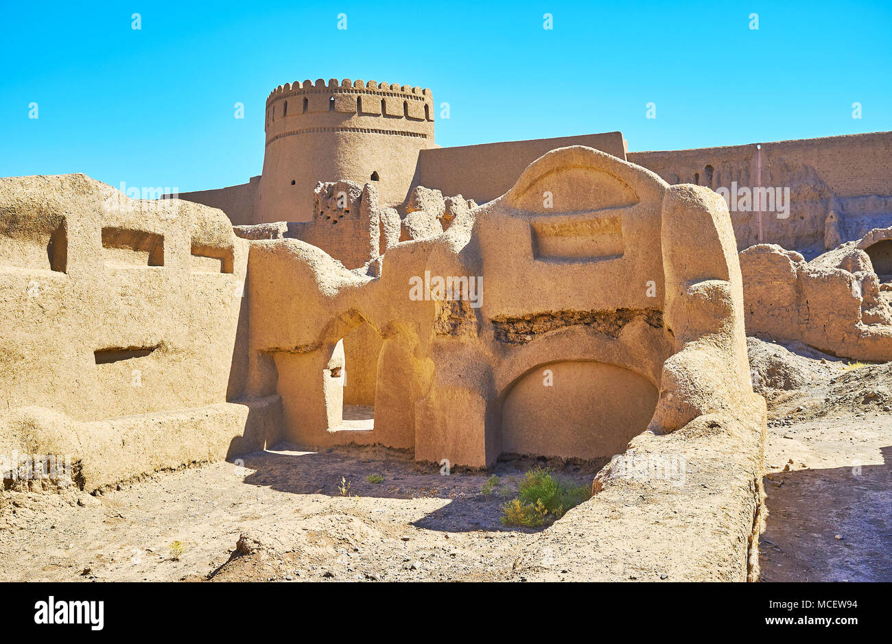 La vue sur le château de Rayen grâce à adobe mur de maison en ruine, province de Kerman, Iran. Banque D'Images