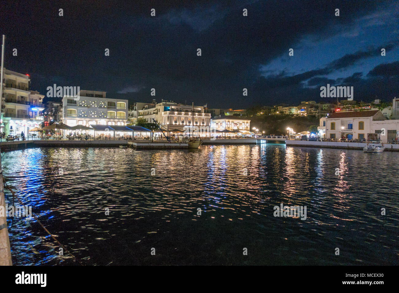 Seascape et bâtiments illuminés la nuit dans Agiolaos Nikos, Crète, Grèce Banque D'Images
