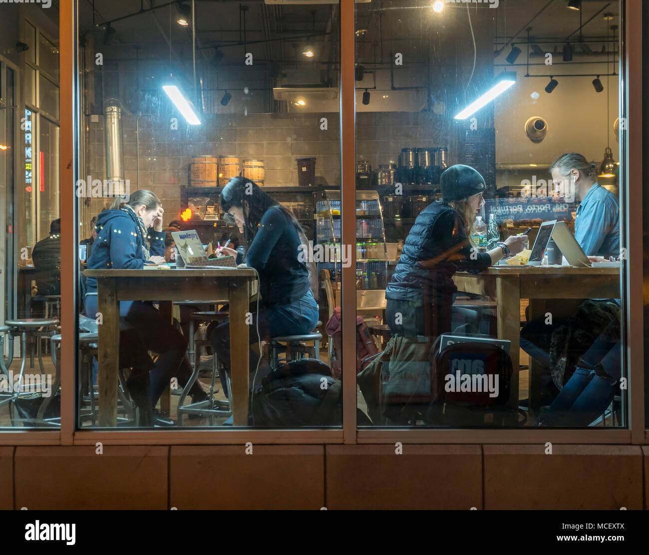 À ses clients de profiter de la connexion Wi-Fi gratuite dans un café à Chelsea à New York le mardi, Avril 10, 2018. Le wi-fi et les tables communes encouragent l'utilisation de la cafétéria comme un espace de co-working. (© Richard B. Levine) Banque D'Images