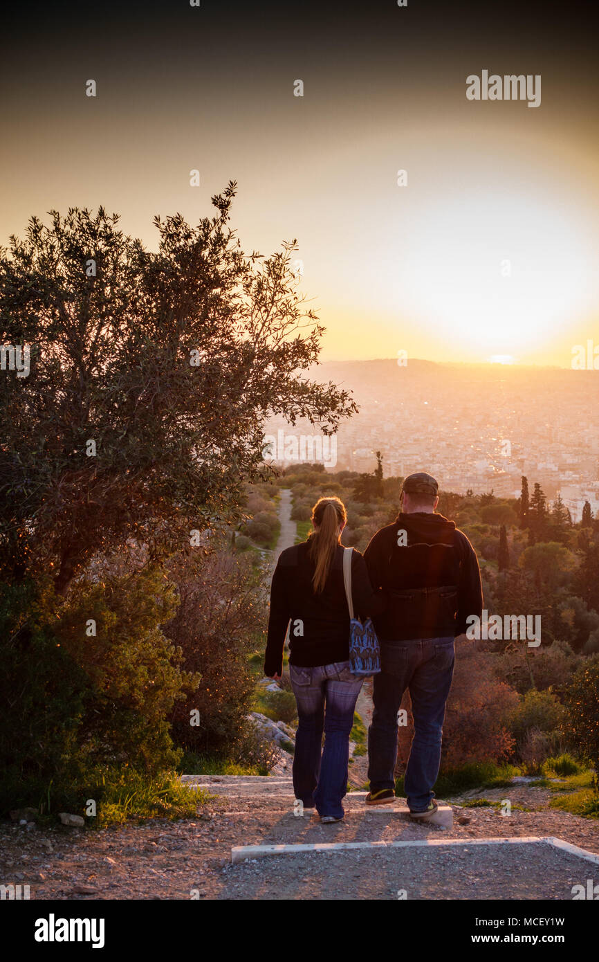 Vue arrière d'un couple en train de marcher en descente, Athènes, Grèce Banque D'Images