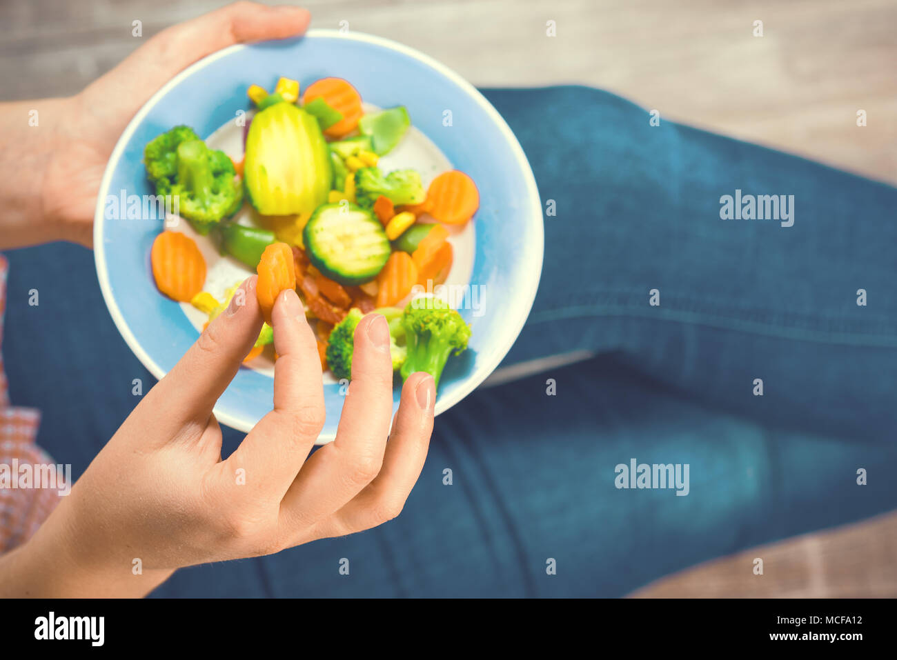 Fille avec un plat de légumes dans les mains. Concept de saine alimentation. Une bonne nutrition. La nourriture végétarienne. Les végétaliens de la nourriture. La tonalité de l'image. Banque D'Images
