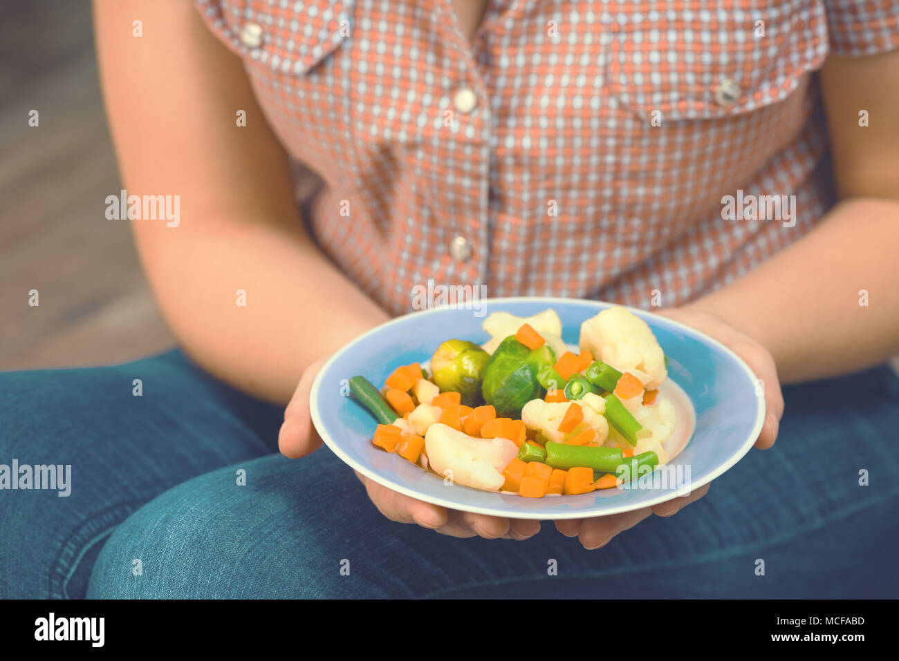 Fille avec un plat de légumes dans les mains. Concept de saine alimentation. Une bonne nutrition. La nourriture végétarienne. Les végétaliens de la nourriture. La tonalité de l'image. Banque D'Images