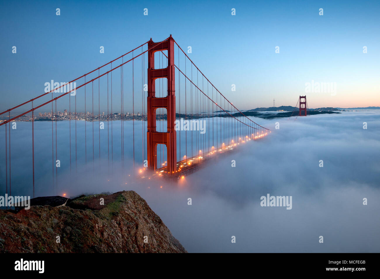 Une vue sur le Golden Gate Bridge, comme le brouillard bas passe sous le soir. Banque D'Images