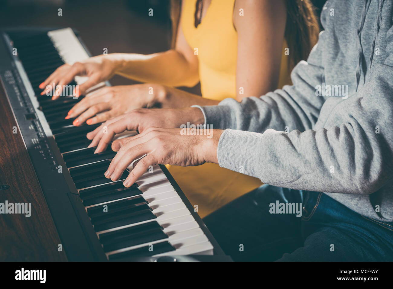 Les joueurs de piano à quatre mains de jouer ensemble Banque D'Images