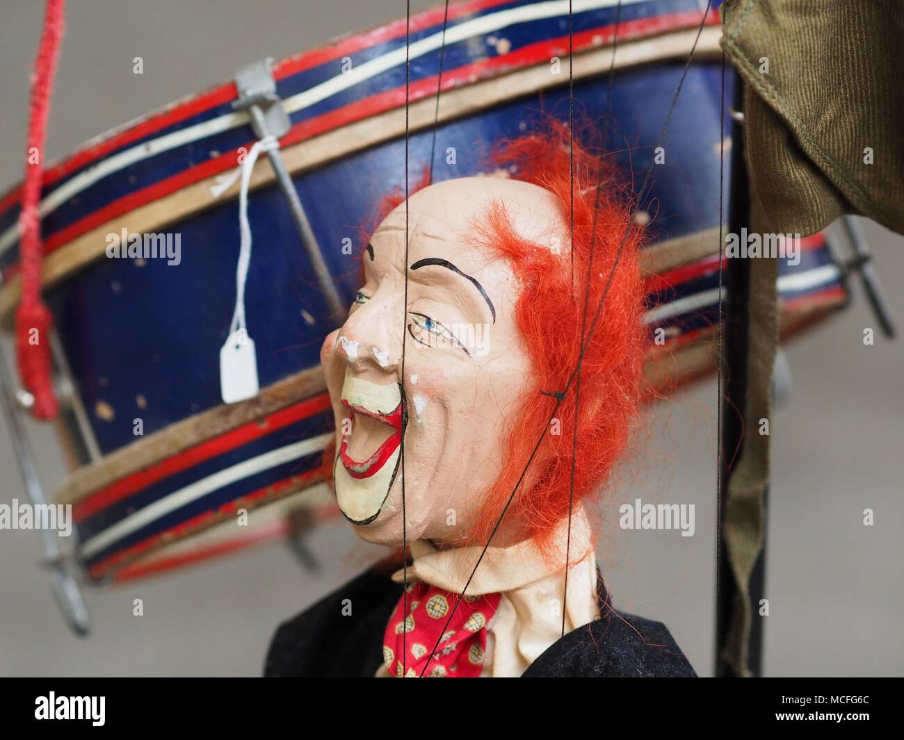 Marionnette clown avec scary face accroché sur un stand avec un tambour antique Banque D'Images Marionnette clown avec scary face accroché sur un stand avec un tambour antique Banque D'Images