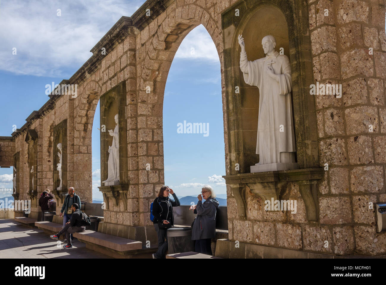Un mur de pierre à l'abbaye de Santa Maria de Montserrat en Espagne avec des arcades et des sculptures représentant des personnages religieux ou des scènes. Banque D'Images