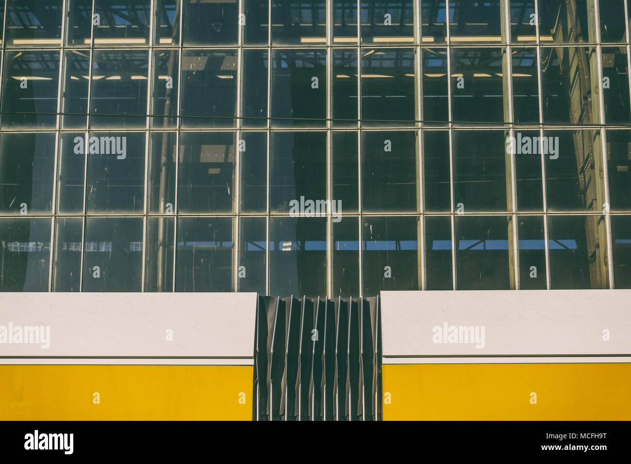 Partie de la gare de tramway jaune contre la façade en verre Banque D'Images