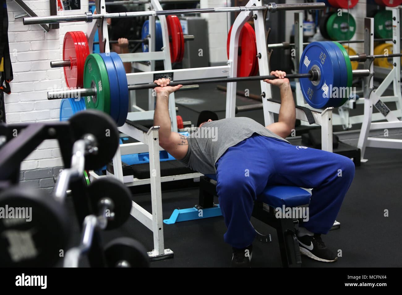 Les hommes de l'exercice et la formation de poids dans une salle de sport à Bognor Regis, West Sussex, UK. Banque D'Images