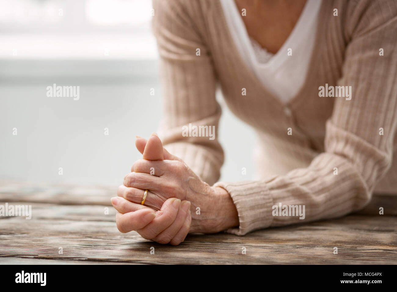 Belle femme d'âge mûr à la recherche de son anneau de mariage Banque D'Images