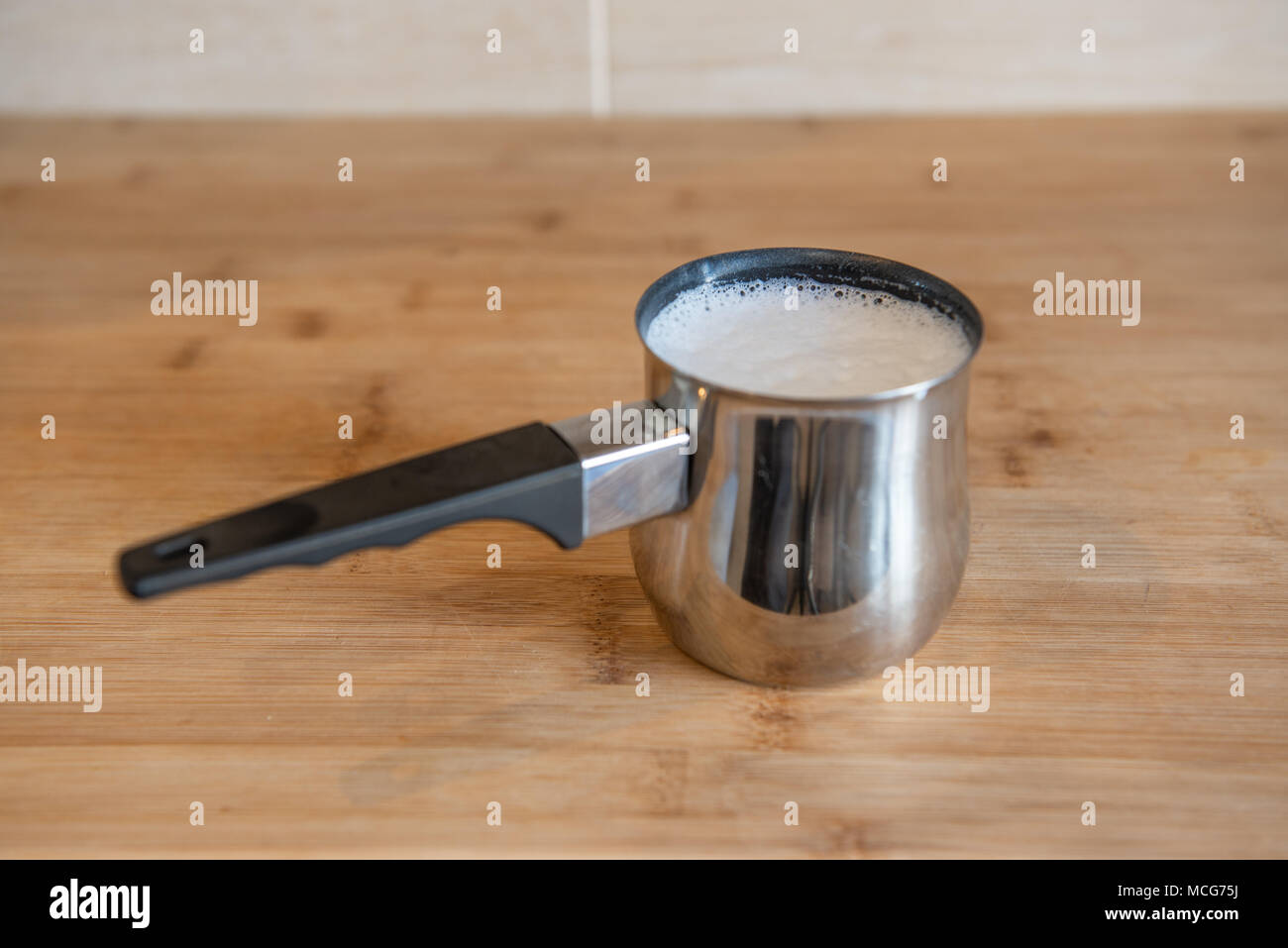 Pichet de lait en acier inoxydable avec lait fouetté Banque D'Images