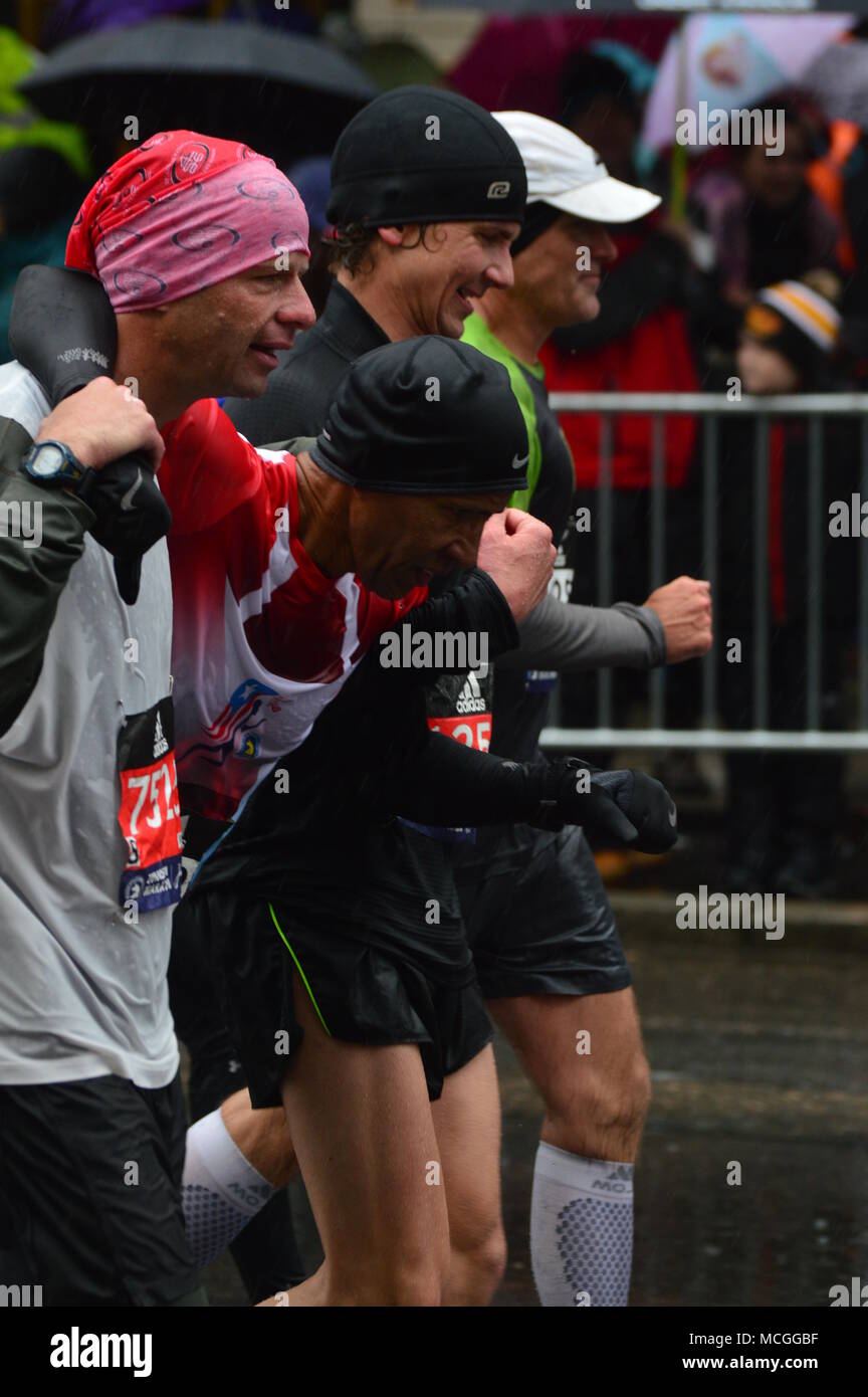 Boston, MA, USA 16 avril 2018 Marathoin porteur aider un coureur blessé comme il apprpoacjhes la ligne d'arrivée du Marathon de Boston/Kirkikis Crédit : James Alamy Live News Banque D'Images