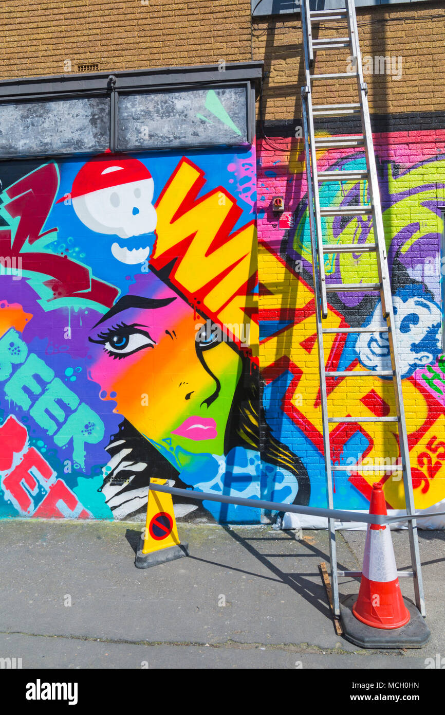 Ceinturée avec les cônes et l'échelle contre le street art mural sur le mur à Brighton, East Sussex, England UK en Avril Banque D'Images